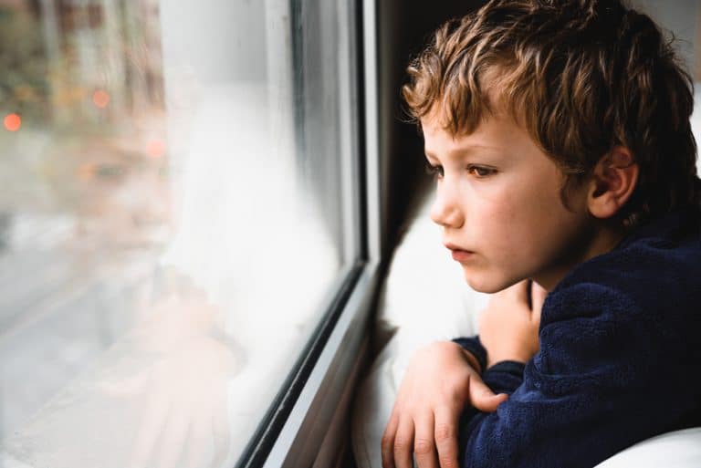 Un enfant regarde par la fenêtre après une séance d'hypnose