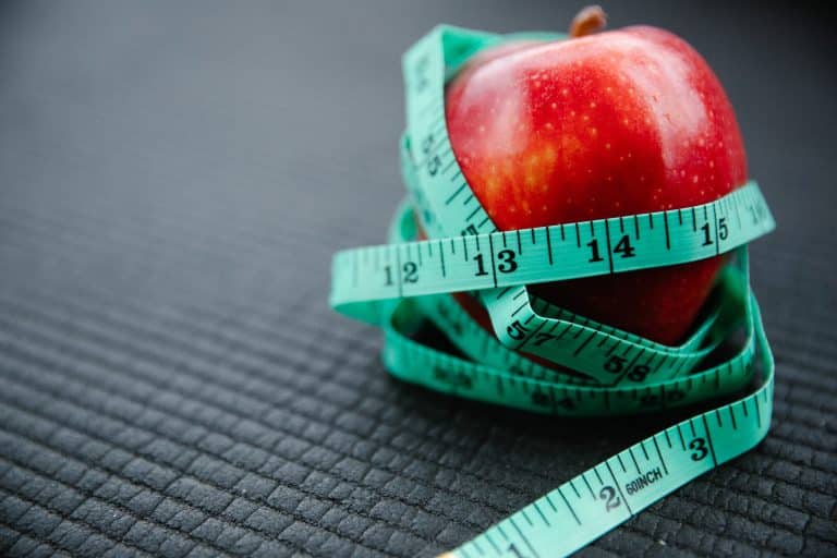 Une pomme rouge entourée d'un mètre de couturière représente les troubles alimentaires possibles