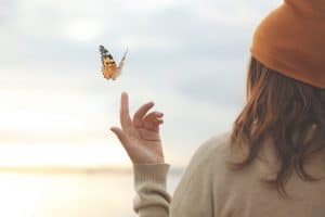 Un papillon s'envole de la main d'une femme